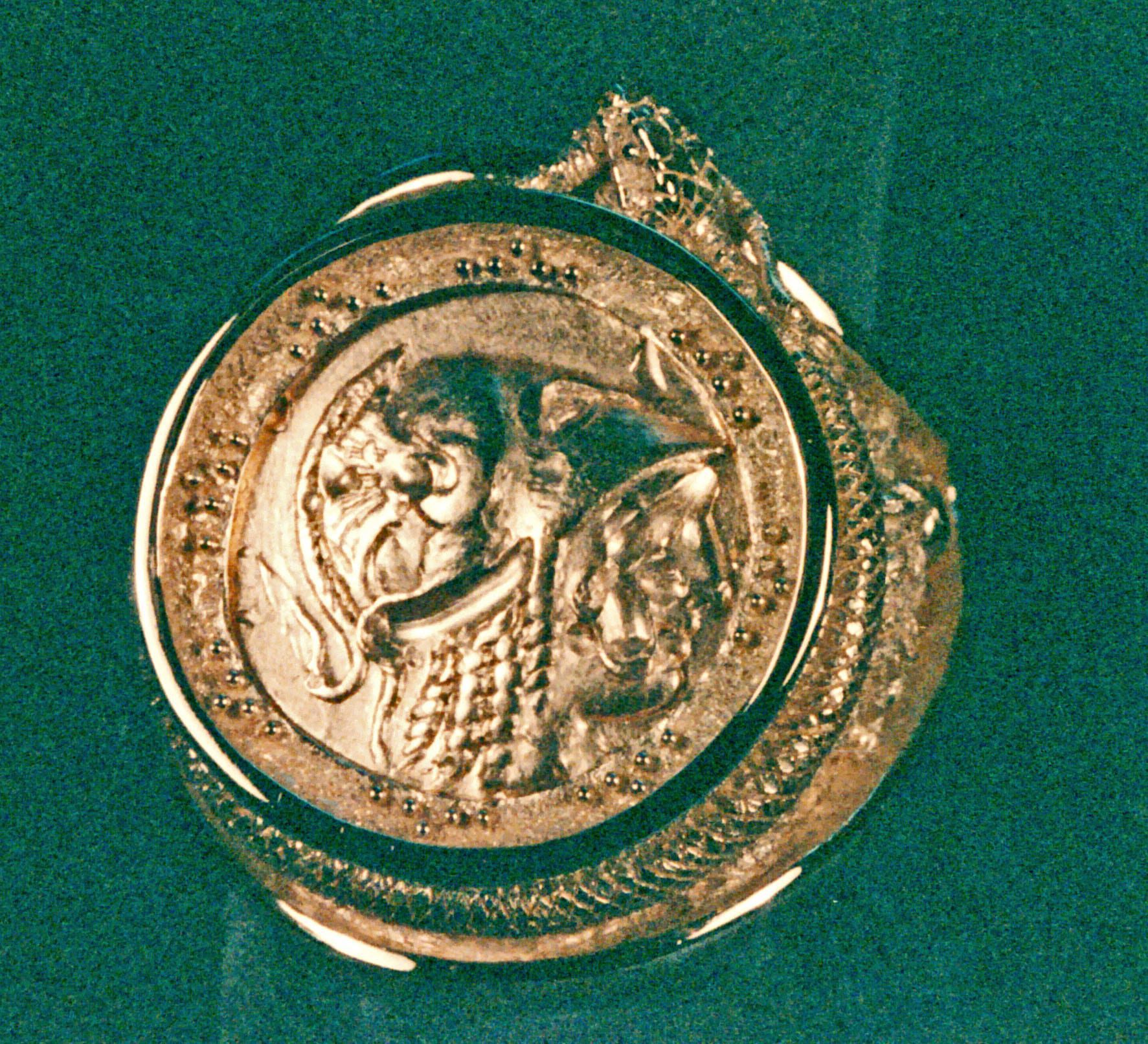 An 18K gold mans ring with symbols of Alexander the Great on it. The coin also has Alexander the Great's head on it and is from 300 BC. the setting is by George Postgate