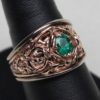 A Viking Gripping Beast wedding ring in rose 14K, and white 14K gold. The borders of the rings are high enough to protect the very fine details of the rose gold center and the fine natural emerald within. Designed and made by George Postgate.
