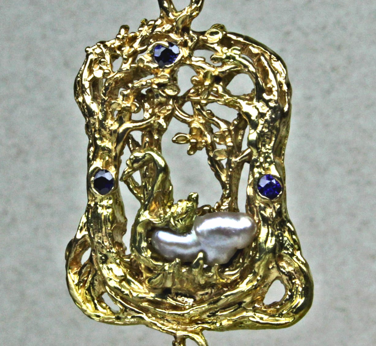 Swan in the forest pendant in 14 kt yellow gold pearl and sapphires by Suzan Postgate