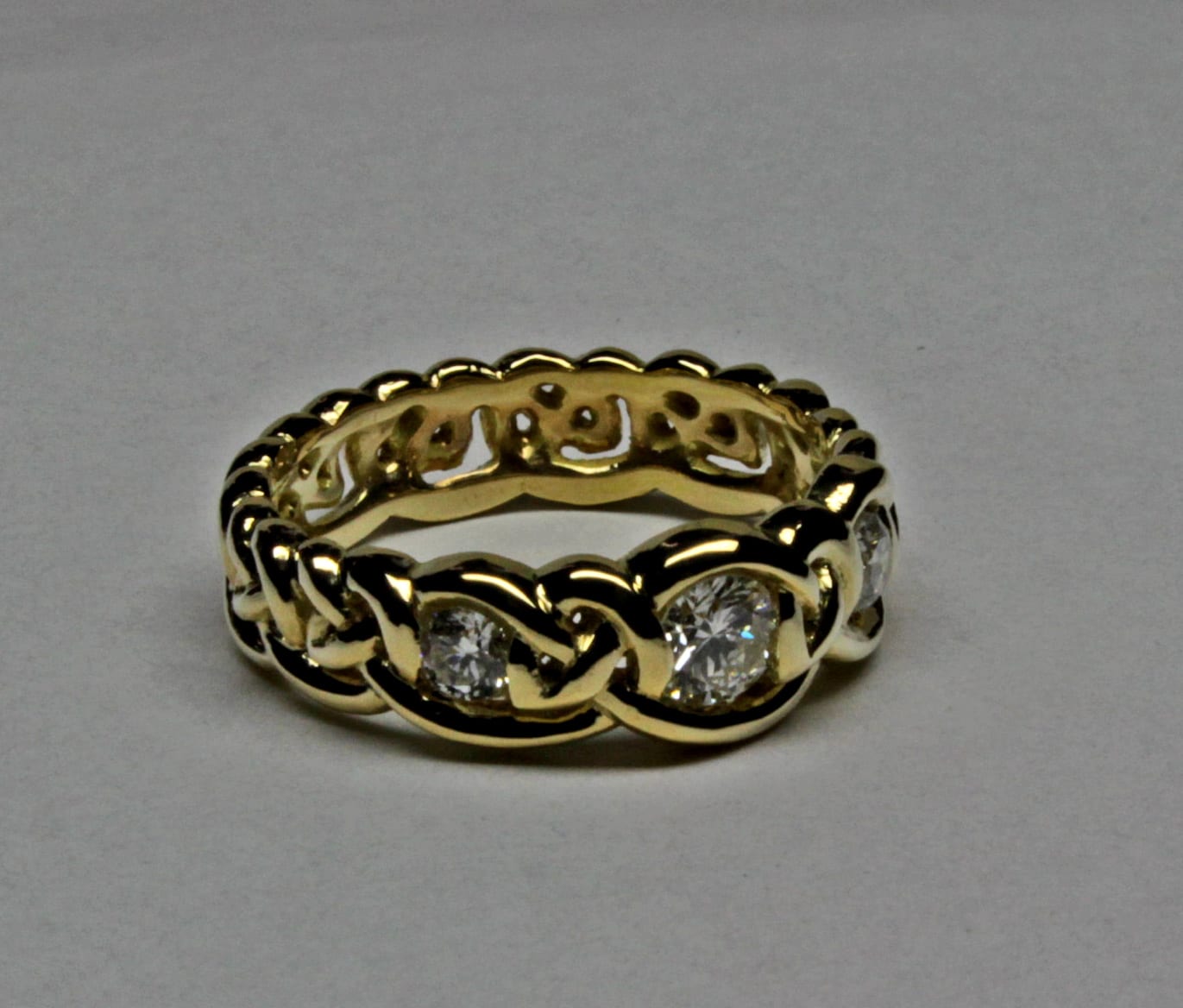 Simple Celtic knot band with three diamonds in 18K by George Postgate