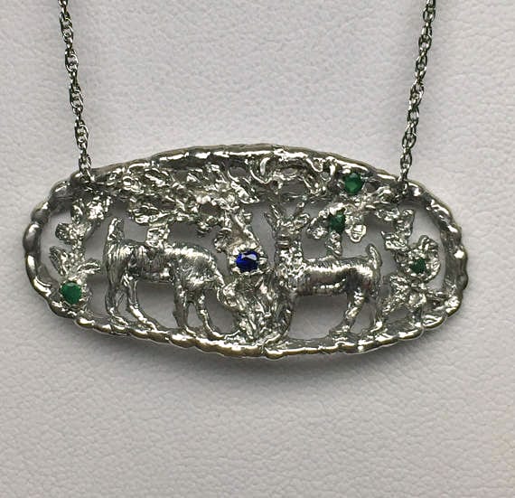 Deer in the Forest Pendant with four emeralds and a sapphire.