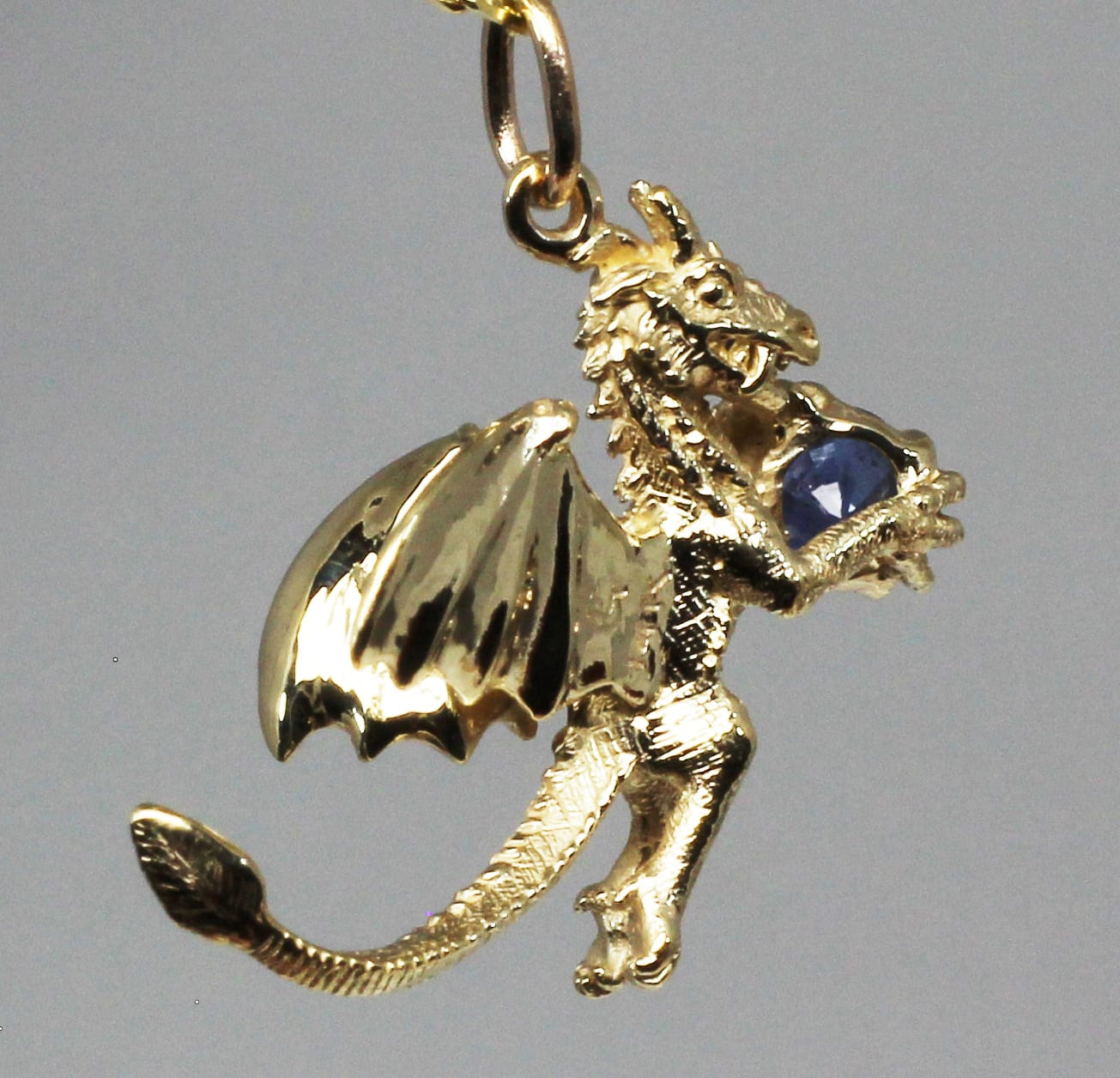 Sapphire dragon pendant 14K A small dragon sculpted out of yellow gold.