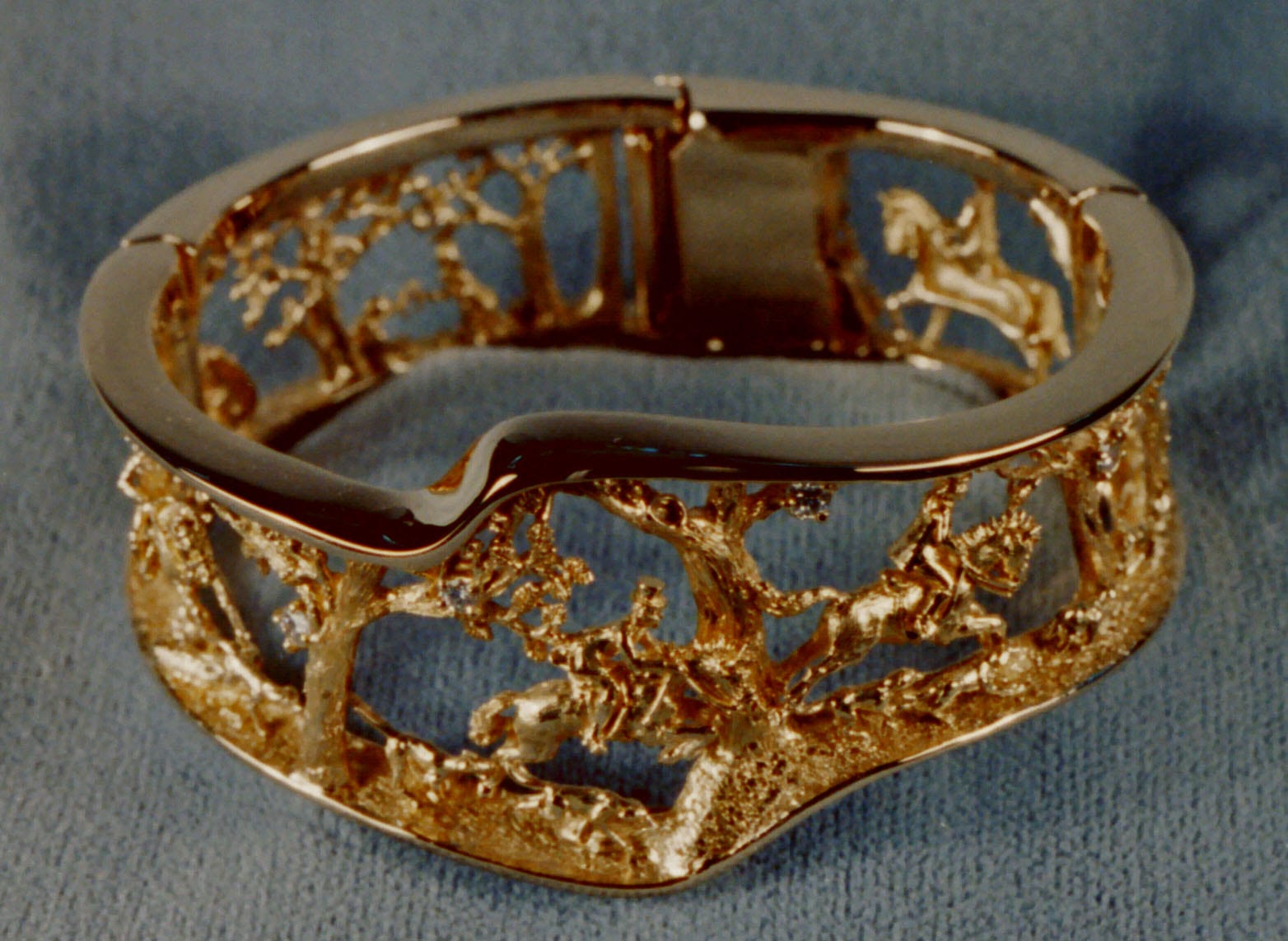 An Equestrian Hunt Bracelet in 18K and diamonds, hand made by George Postgate. Hounds and riders galloping and running through the woods trying to find that elusive fox.